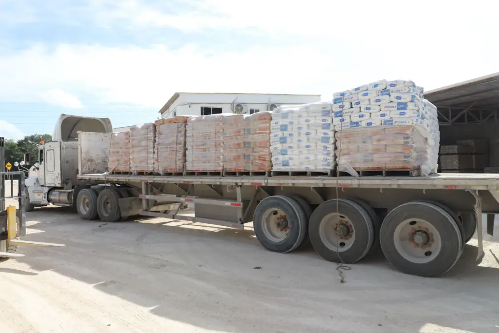 Tráiler de plataforma con tarimas de sacos de cemento CEMEX