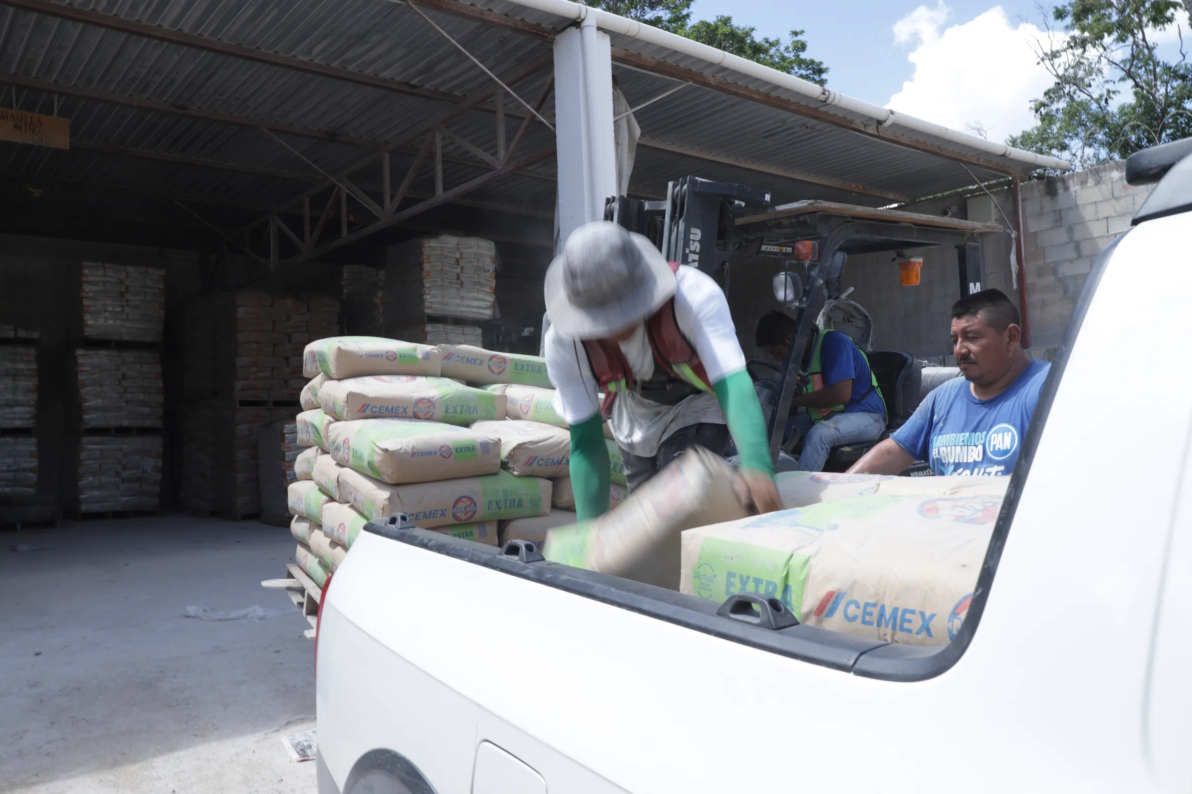 Cargando sacos de cemento CEMEX en una camioneta dentro de la bodega