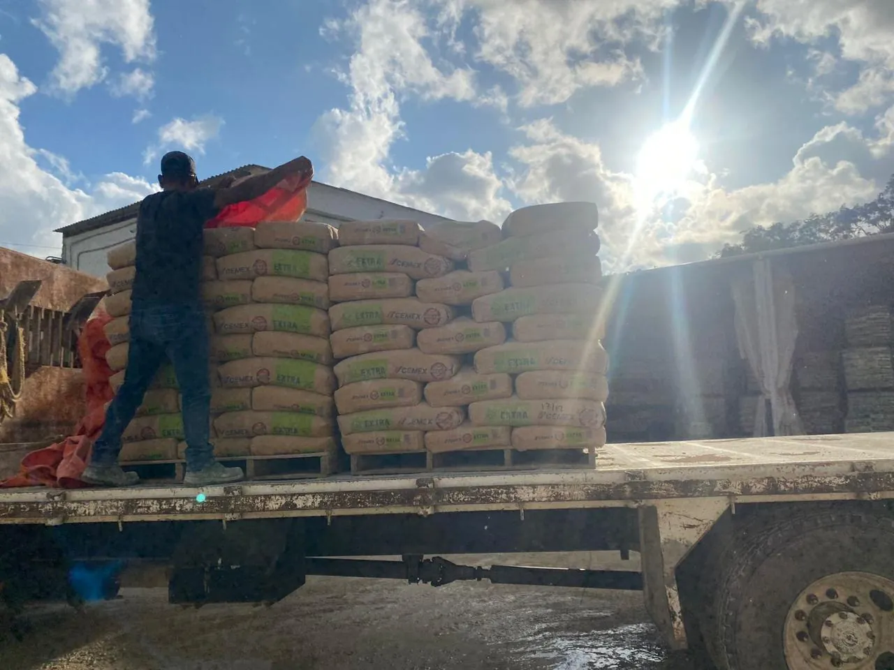 Trabajador acomoda sacos de cemento sobre la plataforma de un camión