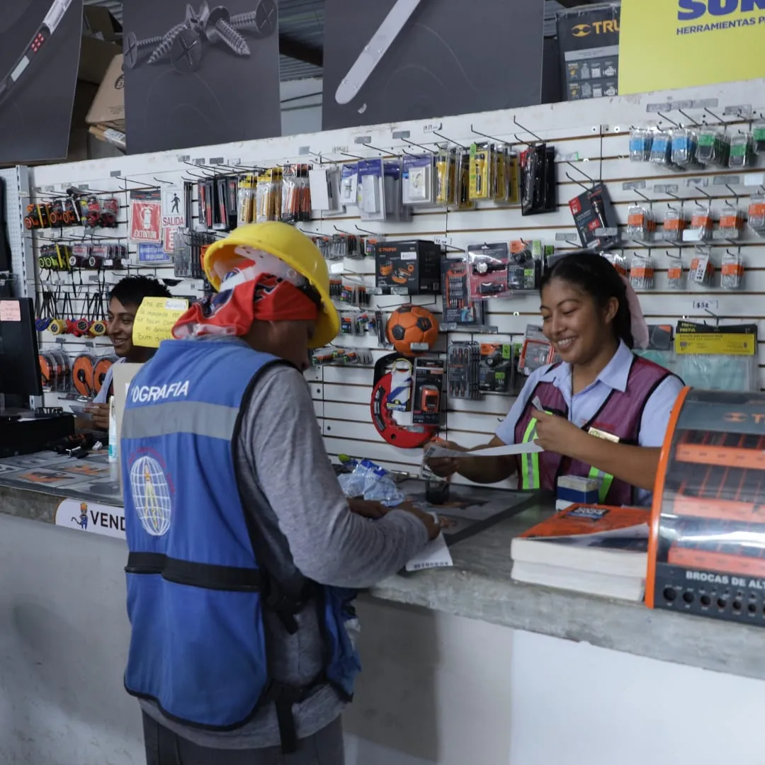 Cliente con chaleco azul atendido en el mostrador de herramienta