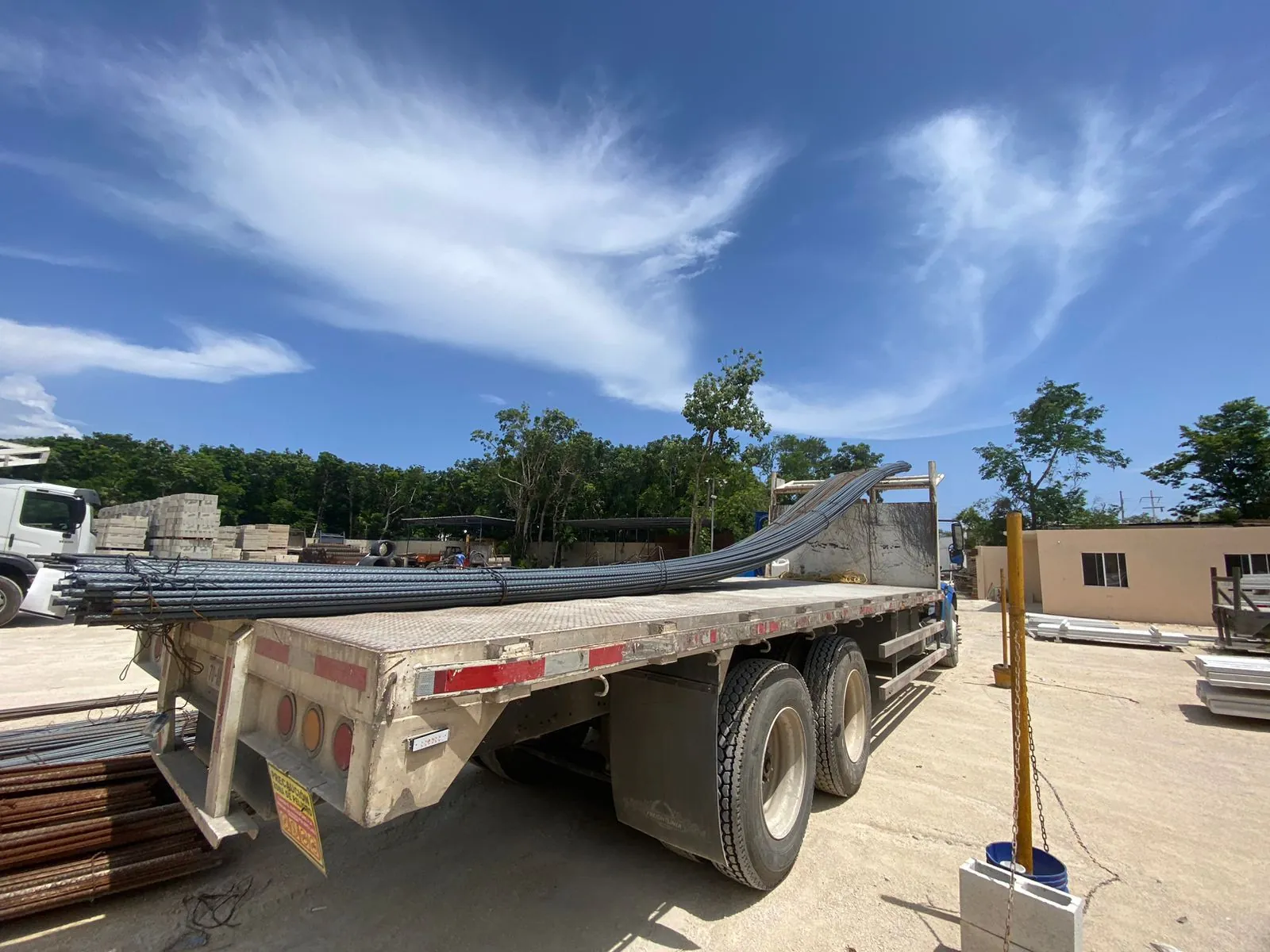 Plataforma de tráiler cargada con varilla en el patio