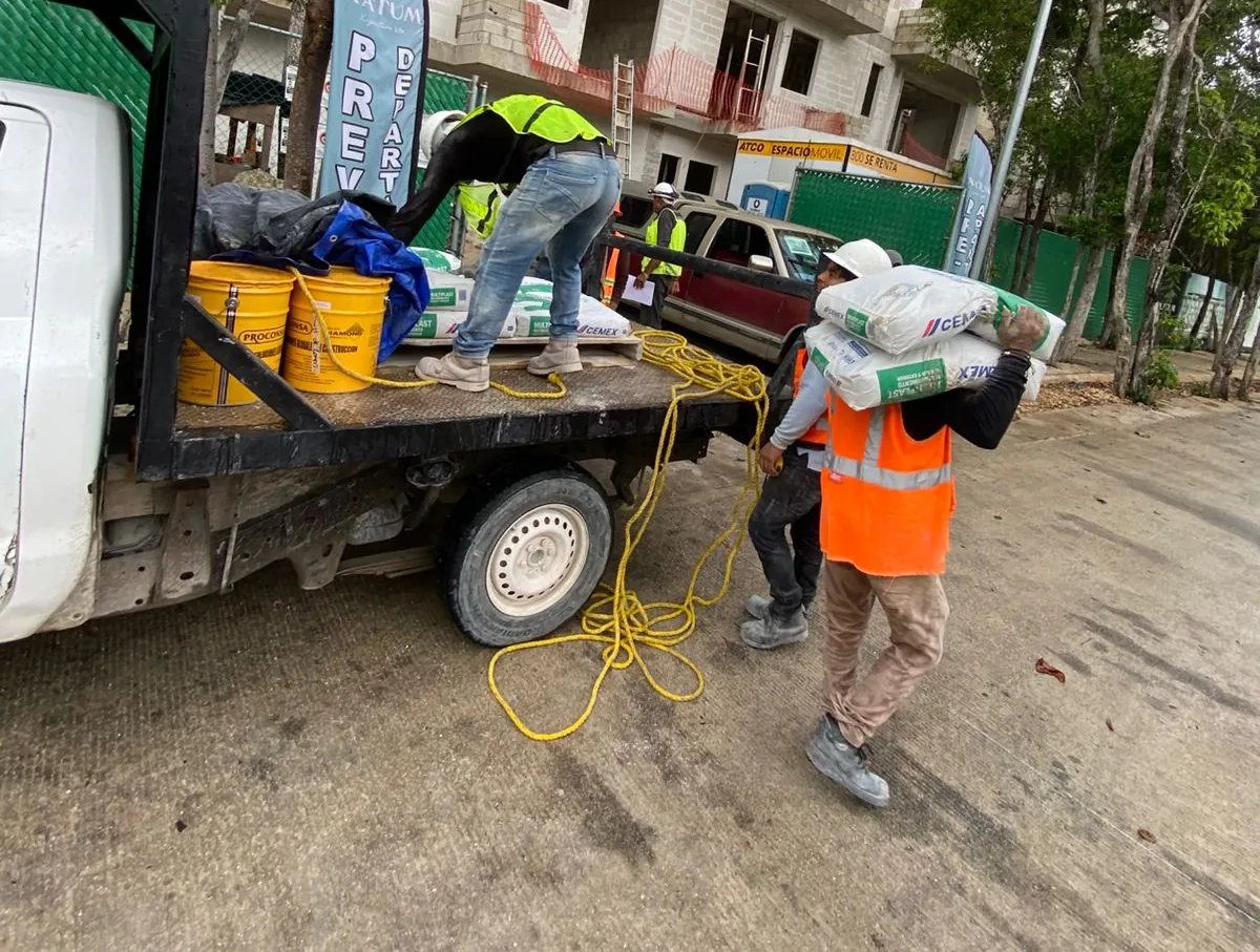 Descarga de cubetas Proconsa y sacos de la camioneta de reparto en una obra