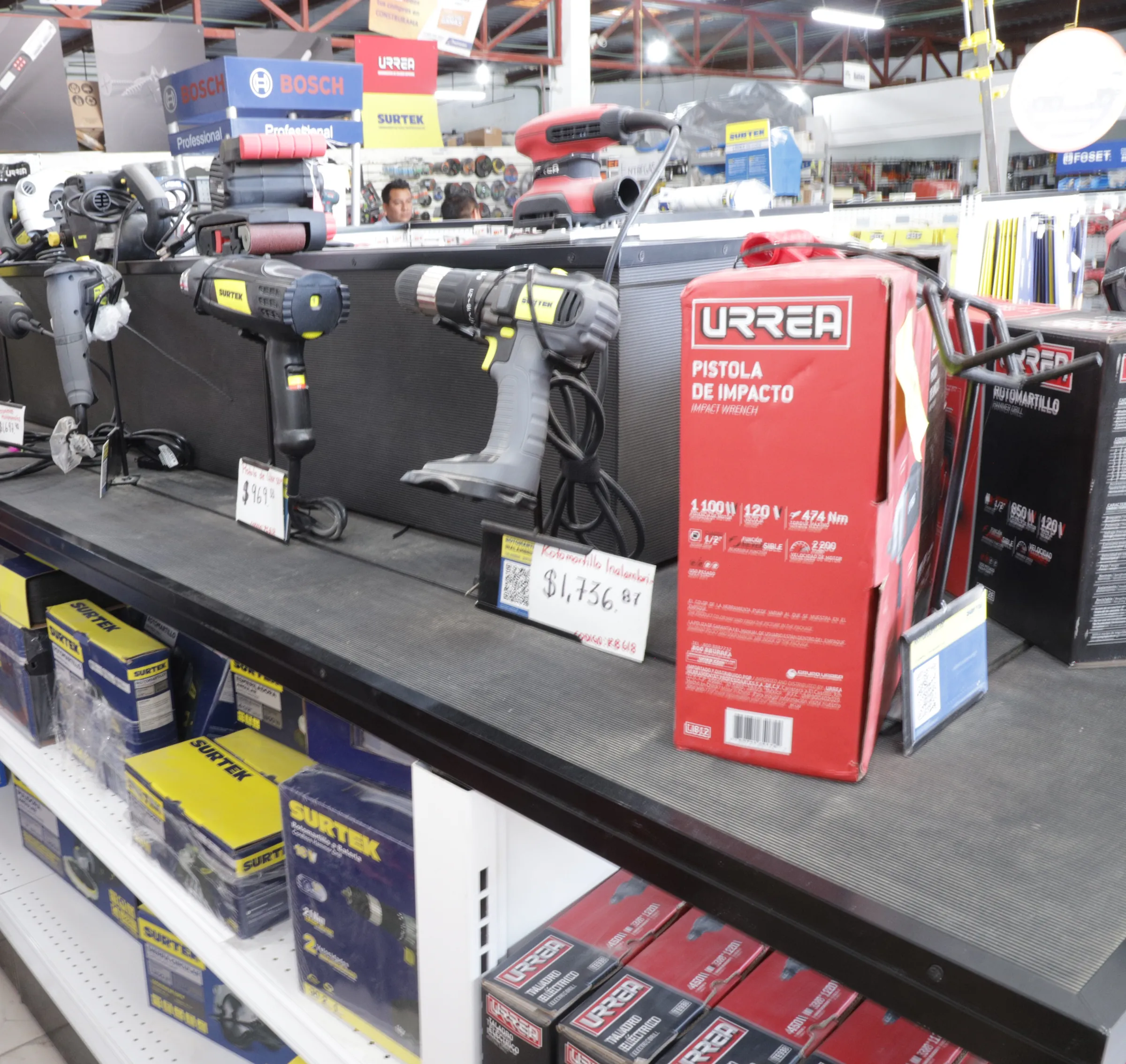 Exhibidor con taladros y una pistola de impacto Urrea en la tienda
